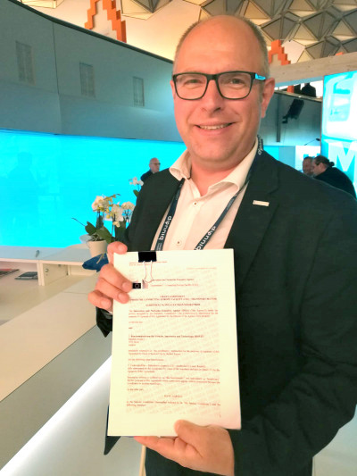 Martin Böhm, Leiter der Business Unit von Austria Tech mit Vertrag in seiner Hand