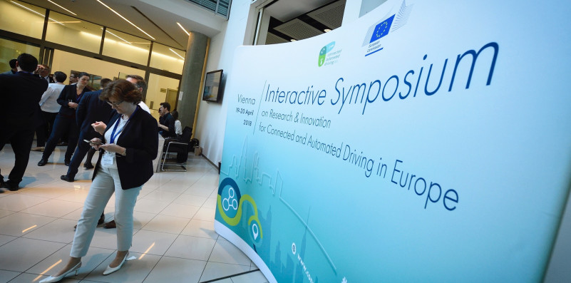 People being busy in front of an interactive symposium sign