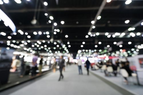 blurry photo of a hall with a lot of people and a glimmering atmosphere with lights that match